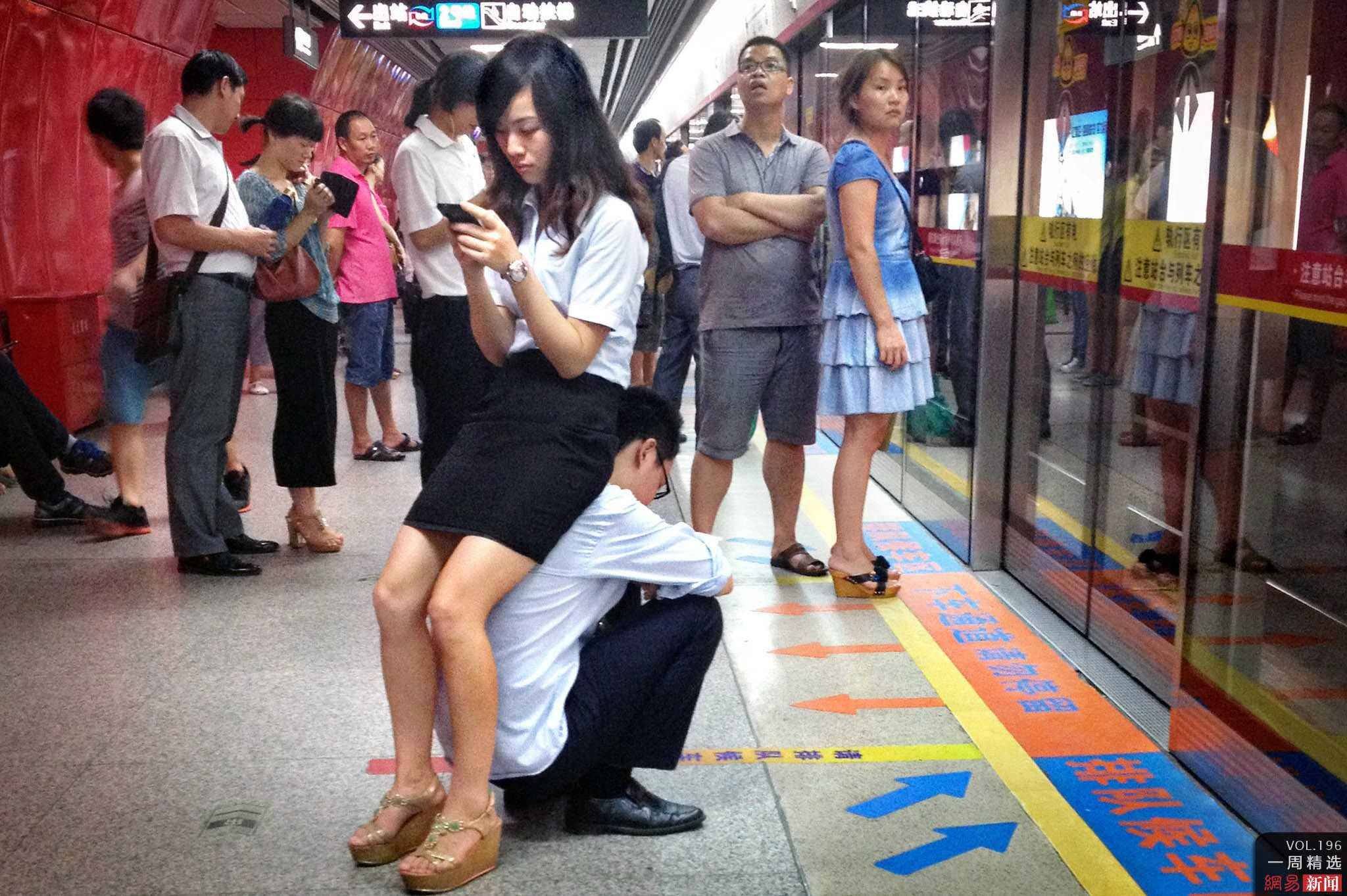 Cina, seduta sul fidanzato| in attesa della metro – FOTO
