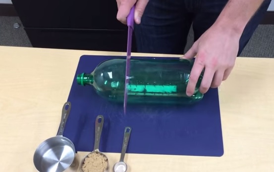 Inizia tagliando una bottiglia e mostra come sterminare le zanzare