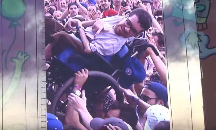 Al concerto sulla sedia a rotelle: la folla lo accompagna sul palco