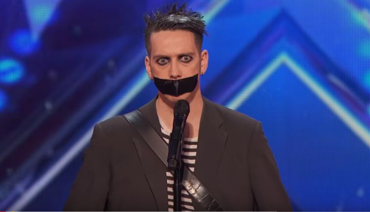 Sale sul palco col nastro adesivo sulla bocca, la sua performance è geniale