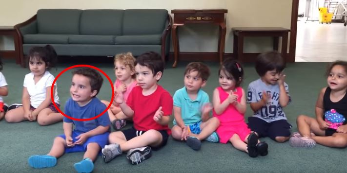 La maestra suona la chitarra, non perdete di vista il bimbo con la t-shirt blu….