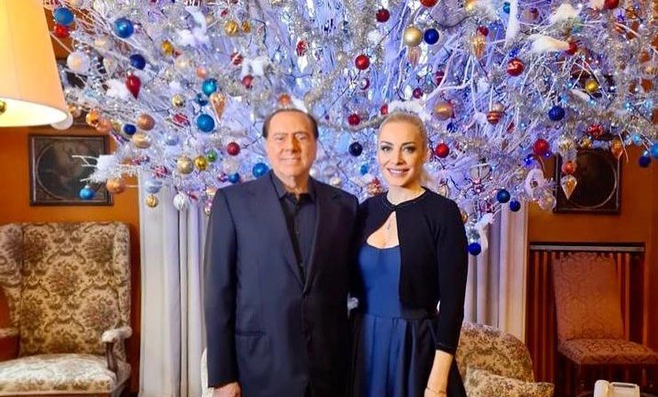 Silvio Berlusconi fa gli auguri agli italiani con cane e fidanzata: “Ora è davvero Natale”